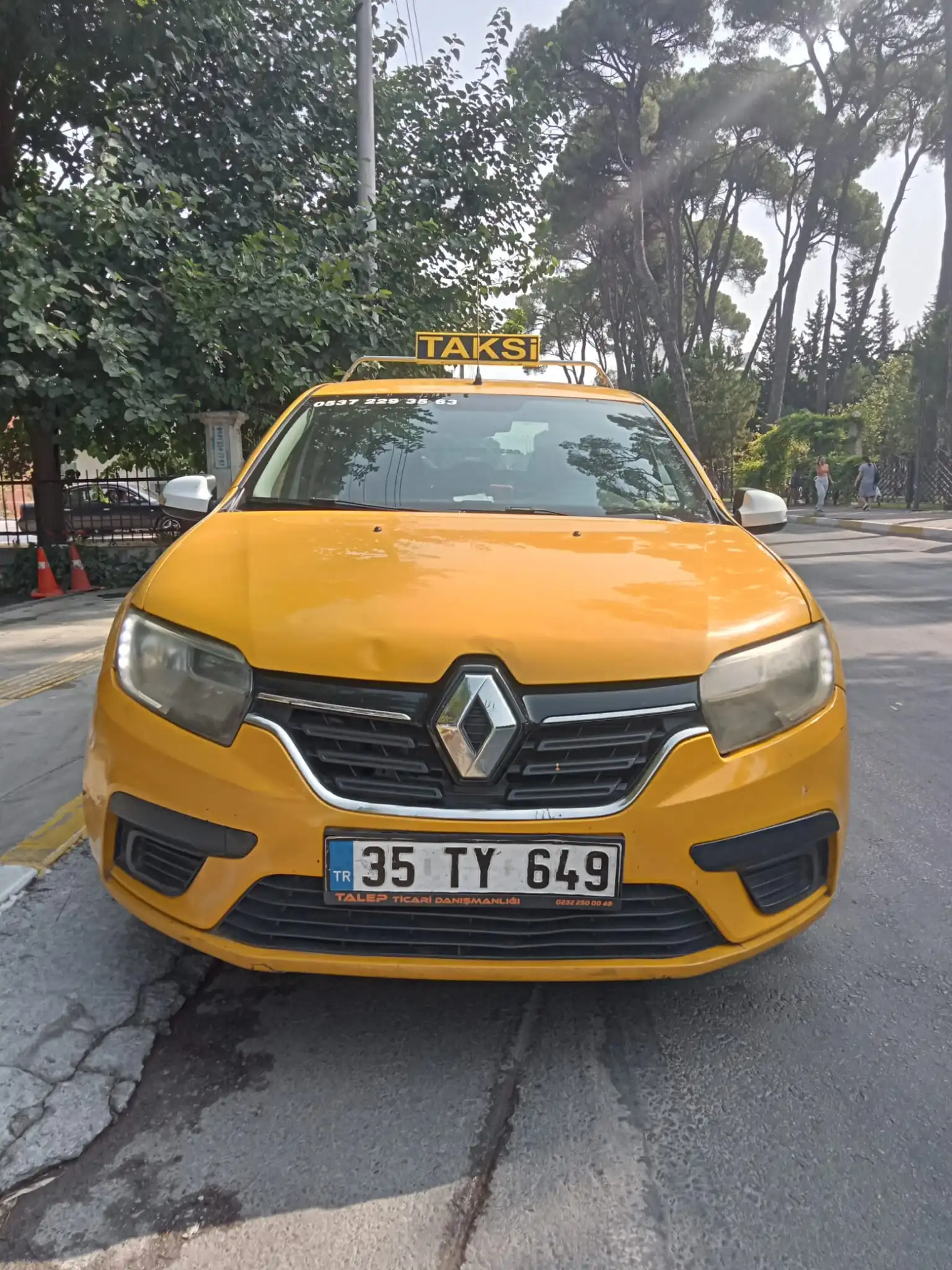 Önden görünen 35 TY 649 plakalı Torbalı Taksi aracı